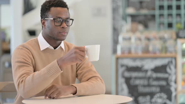 African American Man Thinking While Drinking Coffee in Cafe