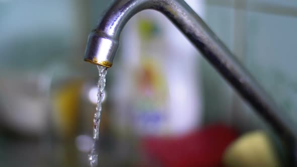 Water Running From the Tap Into a Sink