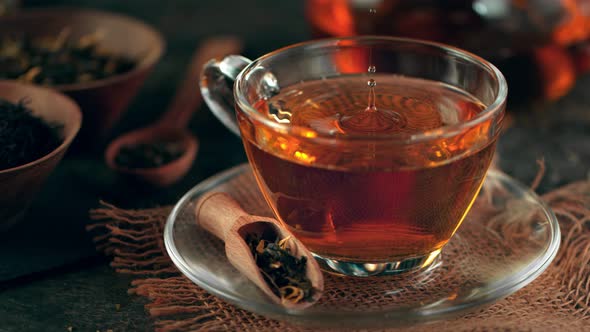 Super Slow Motion Shot of Droplet Falling Into Tea at 1000 Fps with Still Life Background