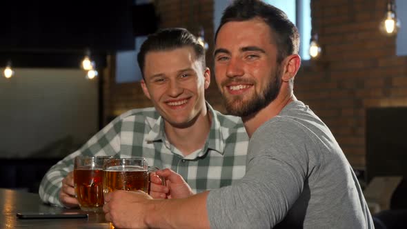 Cheerful Men Smiling To the Camera, While Having Beers at the Bar