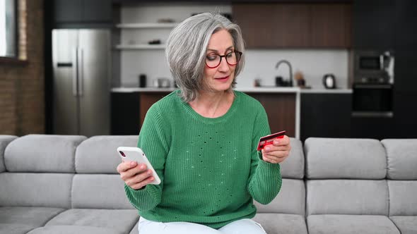 Mature Senior Woman is Using a Smartphone at Home