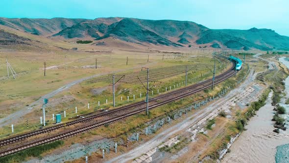 The passenger train travels in the mountains. Afrosiab. Uzbekistan. 4k.