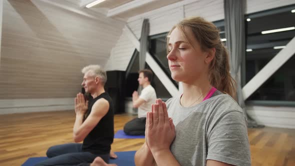 Young Woman Doing Yoga in the Group on the Rug in the Hall. Portrait