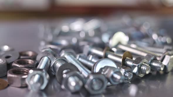 Slider Shot Video of Chrome Bolts and Nuts in a Chaotic Order Industrial Background