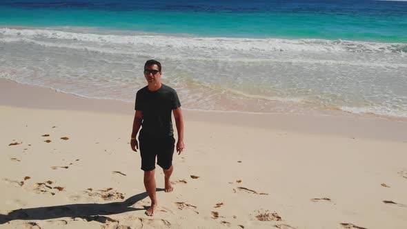 Man Walking Along Coast of Sea Shore