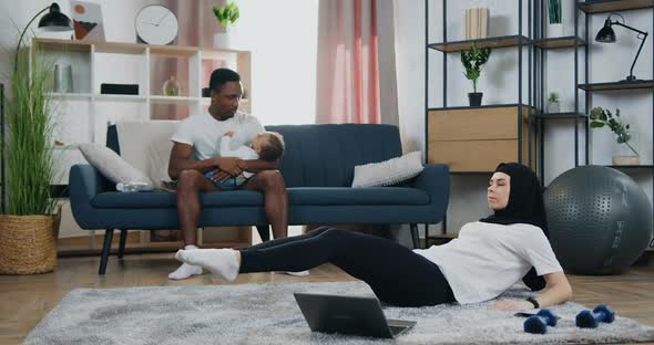 Black-Skinned Guy Listening Modern Music in Headphones while Training on Running Track at Home