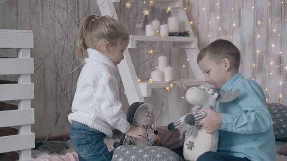 Boy in Light Blue Shirt Plays Toys with Younger Blond Sister