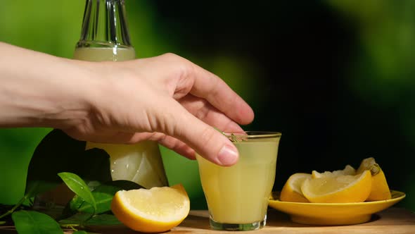 Hand Takes a Shot Glass of Limoncello Drink