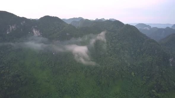 Piece of White Cloud Covers High Green Top of Mountain Range