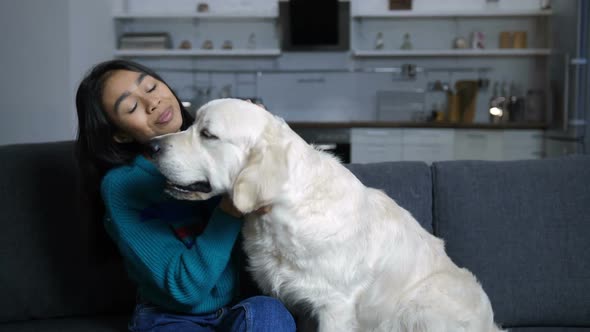Smiling Indian Woman Caressing Dog on Couch