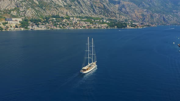 Mediterranean Sea Landscape with Sailboat Sailing on Background Majestic Mountains