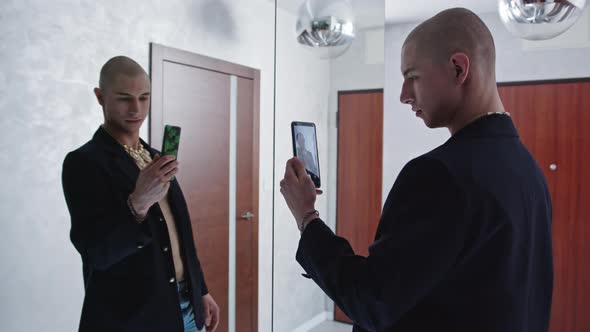 Proud Caucasian Gay Influencer Taking Selfies in the Mirror and Holding His Smartphone