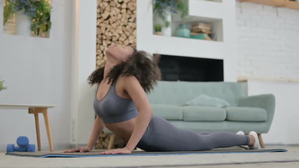 Young African Woman Doing Yoga on Yoga Mat at Home