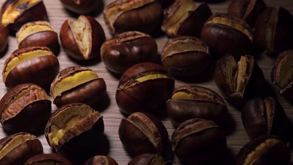 Roasted chestnuts illuminated on wooden background.