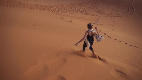 Tourist Running Barefoot Down Desert Sand Dune