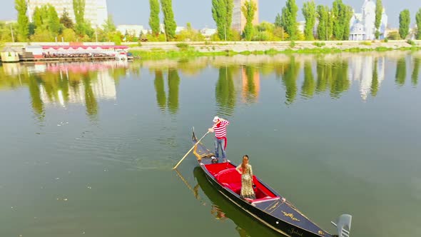 Aerial view of traditional gondola. Gondolier with his gondola paddles in city river