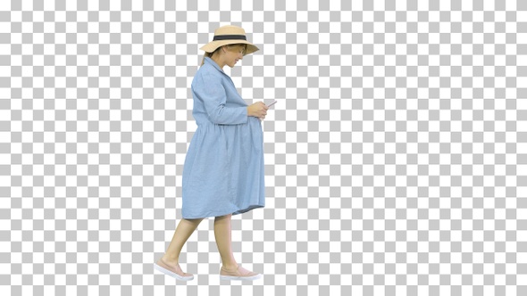 Young pregnant woman in trendy hat walking, Alpha Channel