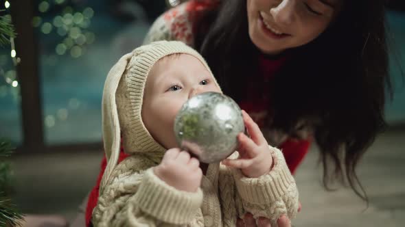 Baby Looks at Toys on Christmas Tree Xmas