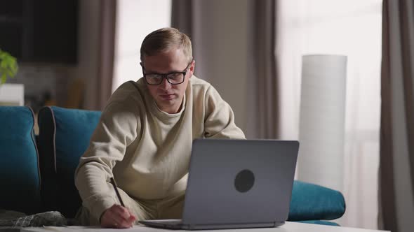 Serious Young Man Freelancer Working on Freelance From Home Typing Email on Laptop Focused Man Using