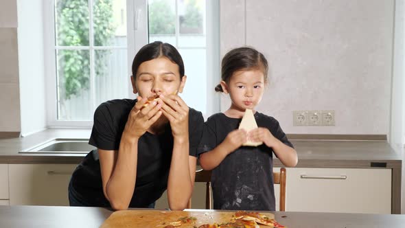 Hungy Mother and Little Girl Eat Delicious Hot Pizza Slices