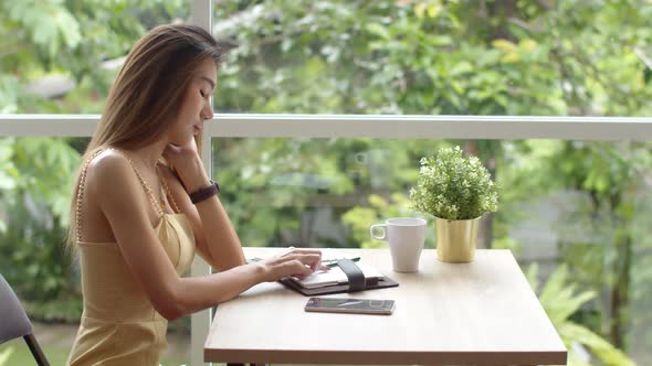 Young pretty woman using smartphone at coffee shop