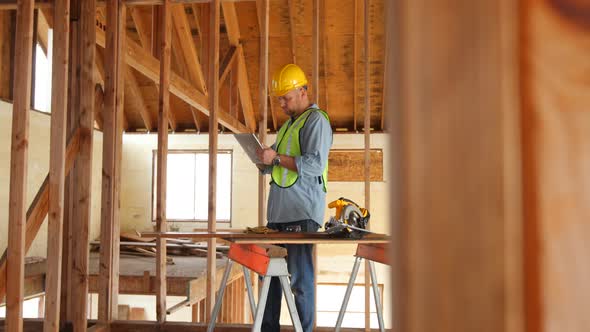 Construction worker using digital tablet on work site alt