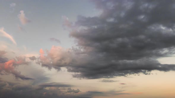 A Moving Panorama of a Dark Evening Sky with Blue Clouds in the Sunlight