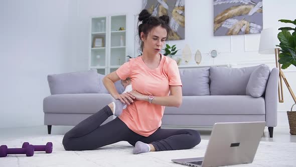 Woman Showing Fitness Exercises  at Home for Her Training Team Via Video Call on Laptop