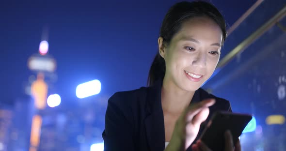 Asian woman use of mobile phone in the city at night 