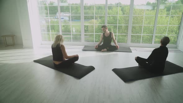 Wellness People of Different Ages Doing Yoga Group of People Relaxing in a White Room Filled with