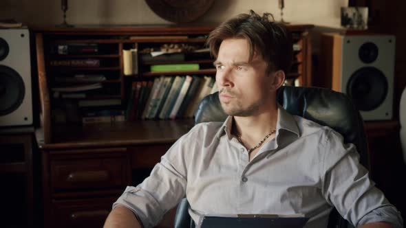 Portrait of a Man Sitting in His Cozy Room with Vintage Furniture Thought Out Because of Heavy