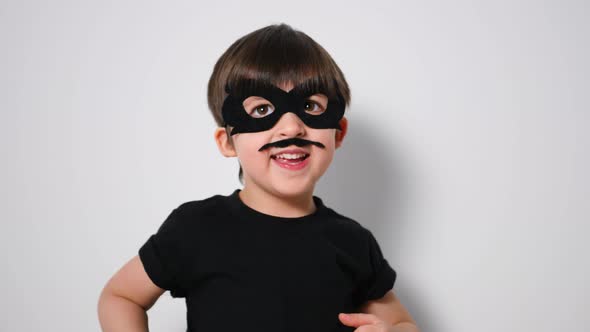 Boy Superhero in a Black Mask and with a Mustache Jumps