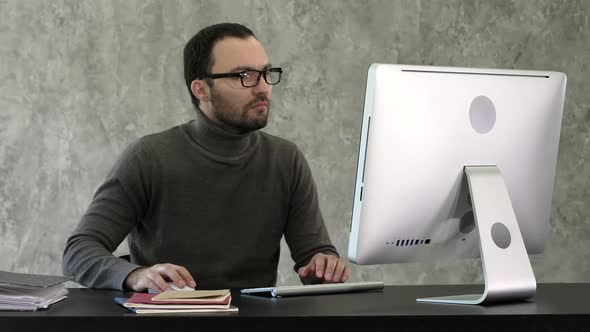 Man Working On Computer In IT Office, Sitting At Desk Writing Codes