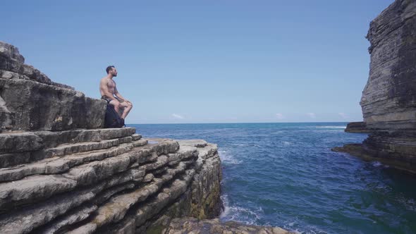 Young man sitting on the seashore.