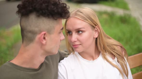 A young beautiful woman looks sensually into the eyes of her young man