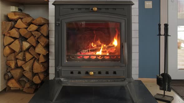 Closeup View of Burning Fireplace with Wooden Logs and Flames Inside