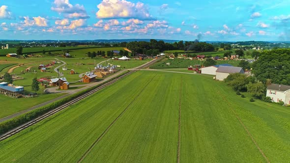 Aerial View of Amish Farm lands With a Single Rail Road Track and a Steam Passenger Train