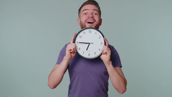 Young Man Holding Clock Watch Hiding Checking Time on Clock Running Late to Work Being in Delay