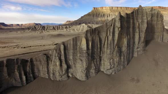 Flying over cliff spires revealing desert landscape covered in tire tracks