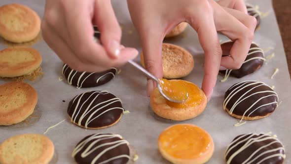 Close-up of a Woman Hand Applying Apricot Jam on Cookies.