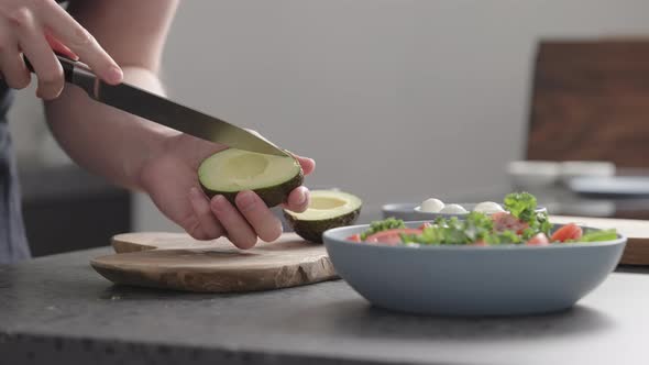 Slow Motion Man Make Salad with Kale Mozzarella Avocado and Cherry Tomatoes Cut Avocado