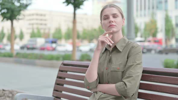 Pensive Woman Thinking while Sitting Outdoor on Bench