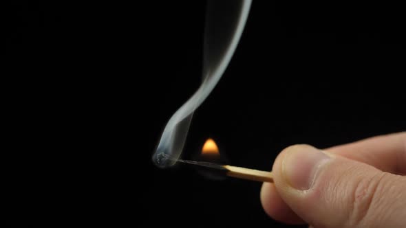 Smoke from Match lighting and burning till the end and finally disappears from the flame on black ba alt