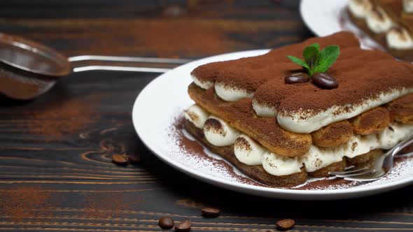 Two Portions of Classic Tiramisu Dessert on Ceramic Plate on Wooden Background