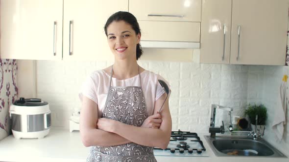 Portrait of Smiling Young Housewife in Modern Kitchen