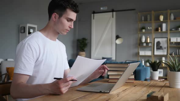Penisve Man Doing Paperwork and Using Laptop