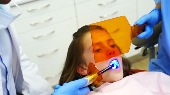 Dentists examining a young patient with tools