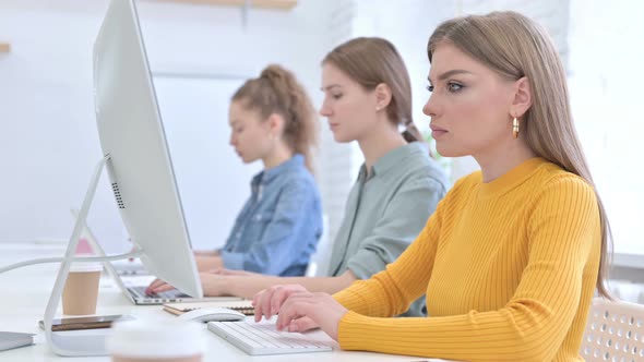 Young Creative Team Working on Desktop and Looking at the Camera