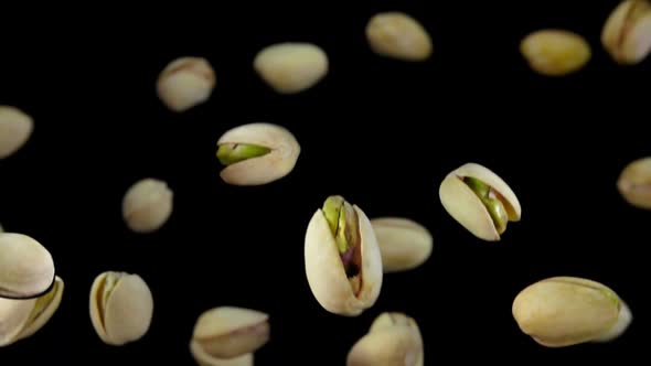 Closeup of the Delicious Pistachios Bouncing and Rotating on Black Background