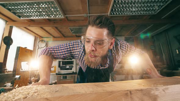 Wood Shavings Are Getting Blown Off By a Craftsman. Craftsman Working in Carpentry.